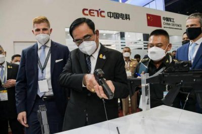 ​巴育被暂停总理职务后首次露面，出席国防展把玩武器